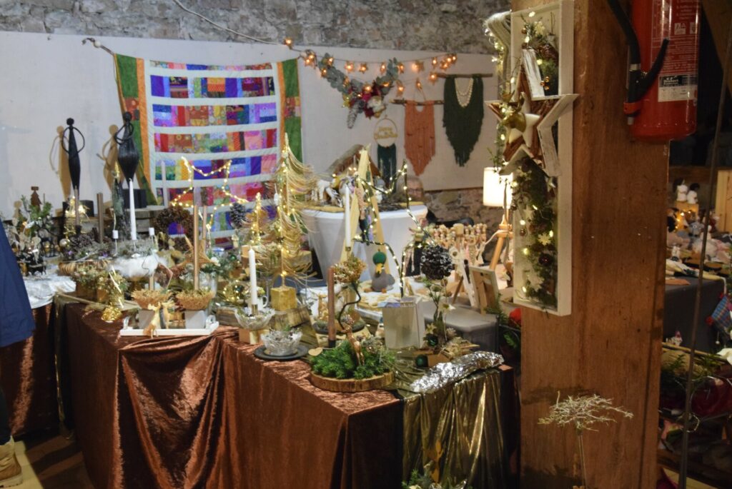 Dekoratives Bild, Langenselbolder Weihnachtsmarkt, ein Stand mit Kränzen und Kerzen