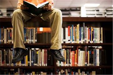 Dekoratives Bild einer Person die in einer Bibliothek auf einem Regal mit Büchern sitzt.